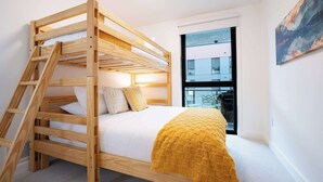 A bunk bed with a wooden ladder, white bedding, and a yellow blanket. - Revelstoke - Bluebird- New condo! (Revelstoke)