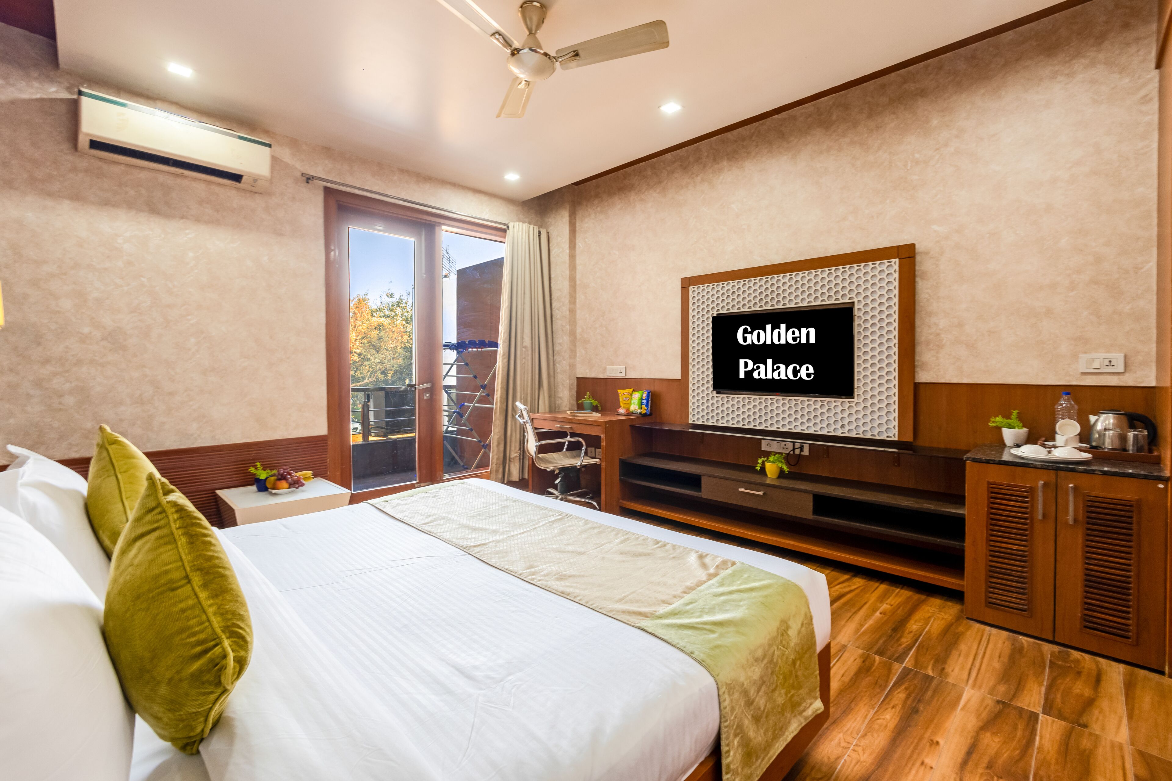 A hotel room with a bed, a desk, a television, and a balcony.