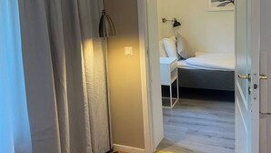 Camera da letto con un letto, una lampada da comodino e una lampada a sospensione.