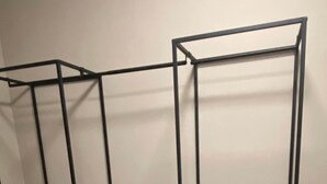 Dos estanterías metálicas negras con cajones, ubicadas frente a una pared de fondo liso.