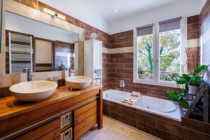 A modern bathroom with two large sinks, a bathtub, and a large mirror. - Le Roucasset – Pool & sea view (Tourrettes-sur-Loup)