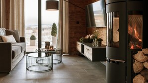 Un soggiorno moderno con camino, un divano, un tavolino da caffè e una TV a parete.