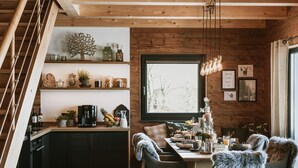 Una cucina accogliente con mensole in legno, un tavolo da pranzo per quattro persone e una scala che conduce a un altro livello.