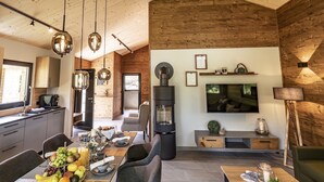 Een moderne keuken met een eethoek, een grote televisie en een open haard.