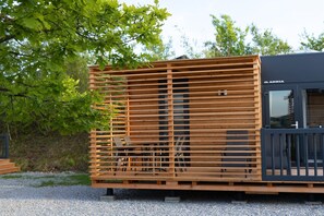A modern wooden structure with a black facade, possibly a part of a building or a temporary installation. - Familienfreundliches MobileHome im Vital Camp Bayerbach (Bayerbach)