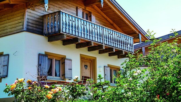 A wooden building with a balcony, windows, and a door. - Familienfreundliches Feriendomizil im Landhausstil im Vital Camp Bayerbach (Bayerbach)