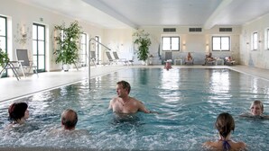A swimming pool with lounge chairs and potted plants around the perimeter. - Familienfreundliches Feriendomizil im Landhausstil im Vital Camp Bayerbach (Bayerbach)