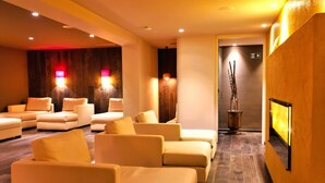 A modern, well-lit lounge area with multiple sofas and a fireplace. - SCHLOSSHOF SÜDTIROL – Hotel & Camping Resort (Lana)