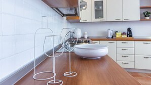 Una cocina moderna con armarios blancos, encimera de madera y un tazón grande y blanco.