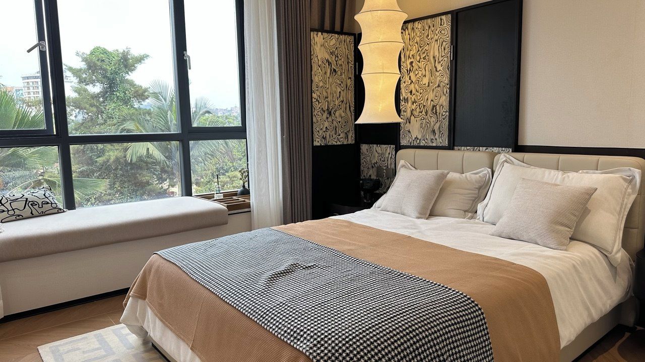 Camera d'albergo con un letto grande, una panca e vista sul verde.