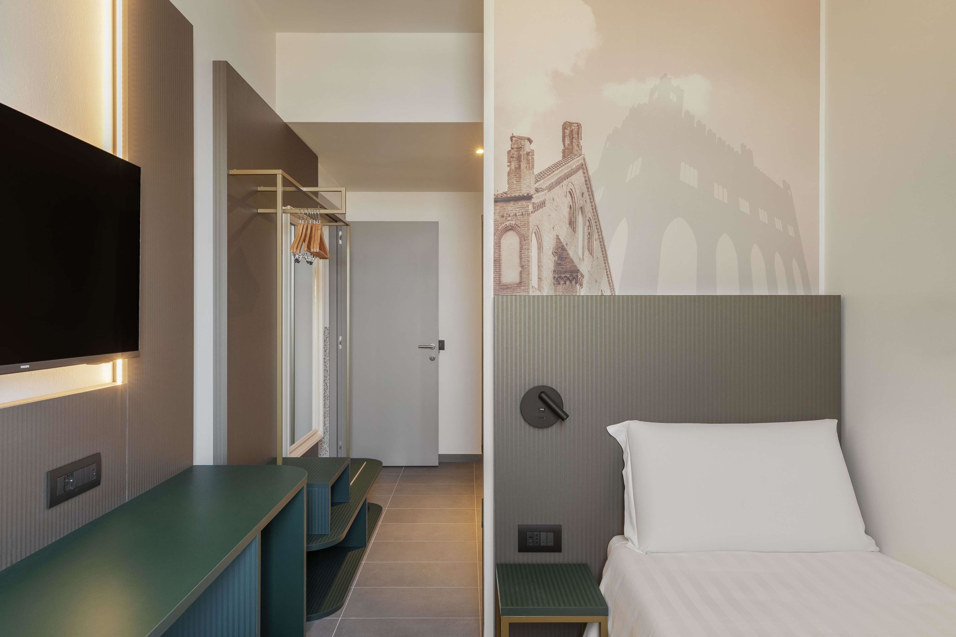 Une chambre d’hôtel équipée d’un lit, d’une télévision, d’un bureau et d’une armoire.