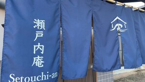 A set of blue curtains with white text and a logo, hanging from a wooden rod.