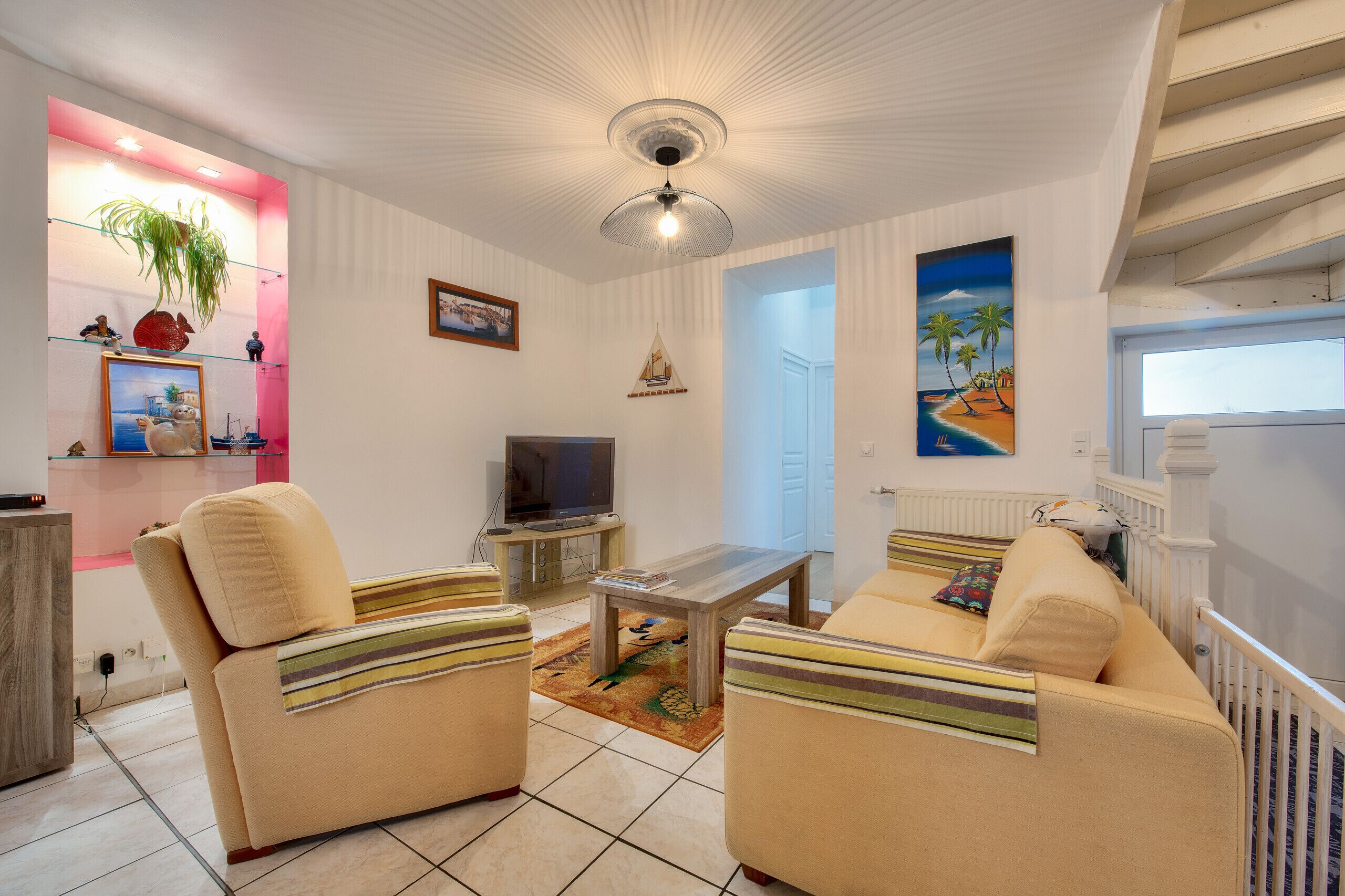 A living room with two sofas, a coffee table, a TV, and a painting on the wall.