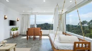 Ein modernes Schlafzimmer mit großem Fenster, einem Hängebett, einem Fernseher und einem Essbereich.