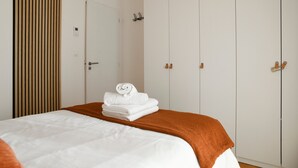 A hotel room with a bed, a wooden slat wall, a white door, and a wardrobe with two doors. - La Grangette Wifi Parking Terrace (Cruet)