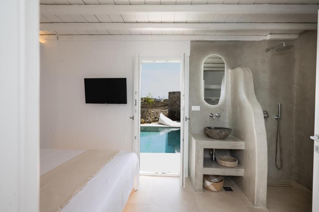 A modern bathroom with a built-in shower, a large mirror, and a sink with a bowl.