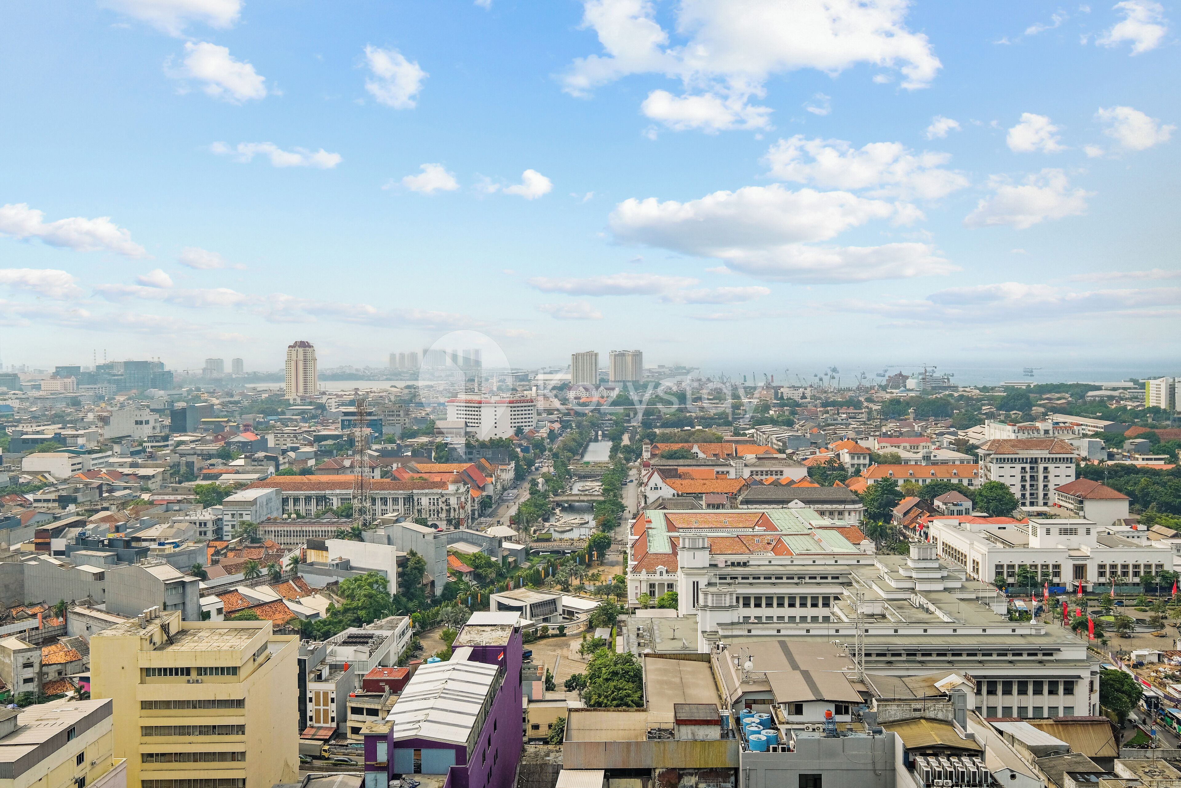 Paisagem urbana com diversos tipos de edifícios, incluindo arranha-céus e edifícios baixos, sob um céu limpo.