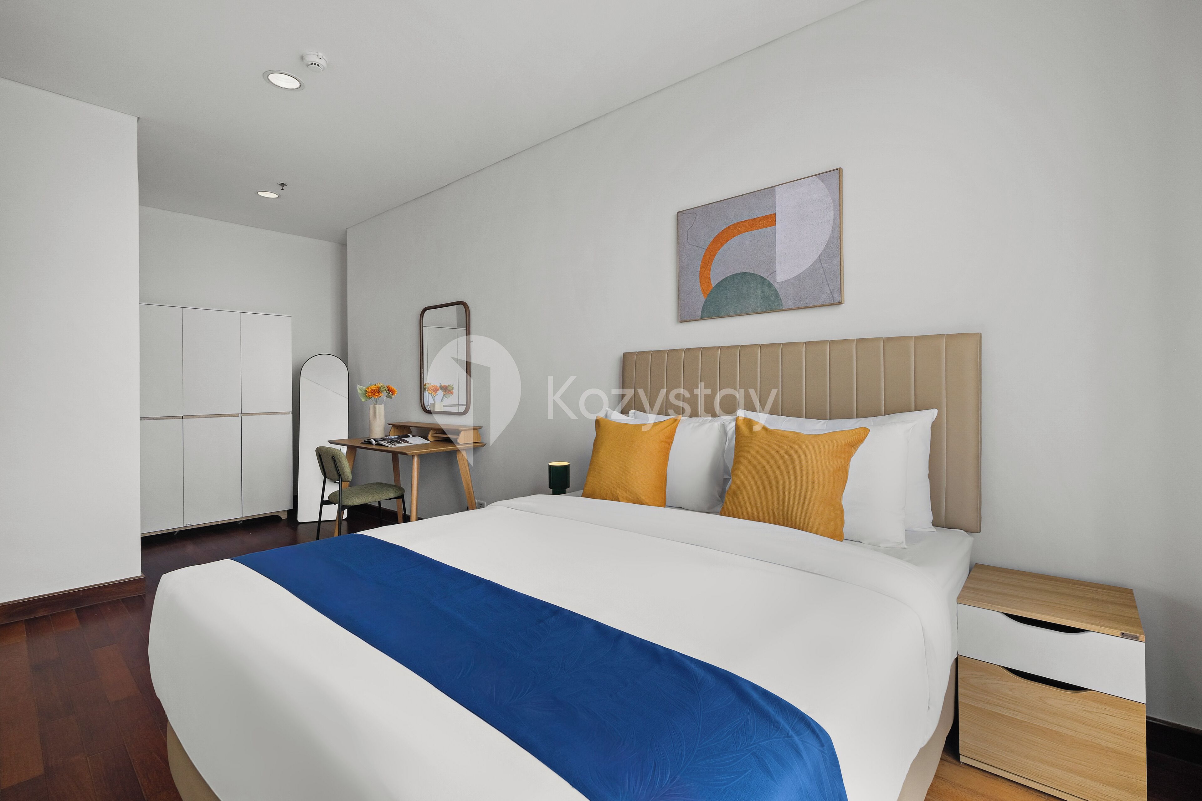 Une chambre d’hôtel avec un grand lit, un bureau, une chaise et une table de chevet.