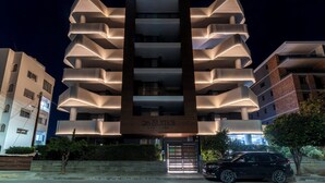 Ein mehrstöckiges Hotel mit modernem Design, ausgestattet mit Balkonen und einem zentralen Eingang.