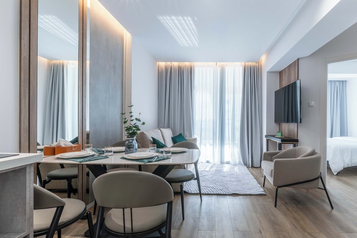 Une chambre d’hôtel moderne équipée d’un coin repas, d’un canapé, d’une télévision et d’un lit.