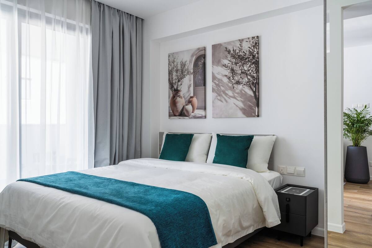 Una camera da letto moderna con un letto, un comodino e una pianta in vaso.
