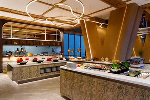 Una cocina moderna con una isla central, iluminación colgante y vistas a la ciudad.