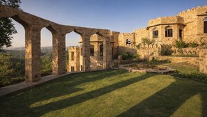 An ancient stone structure with arches and a courtyard. - Raht Manmatha (Udaipur)