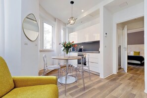 Eine moderne Wohnung mit Essbereich, Küche und einem Bett.