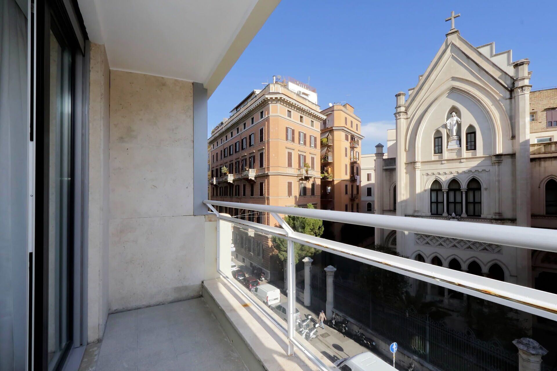 A balcony with a view of historic buildings and a church.