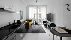 Una sala moderna con un sofá, una mesa de comedor y una zona de cocina con fregadero y estufa.
