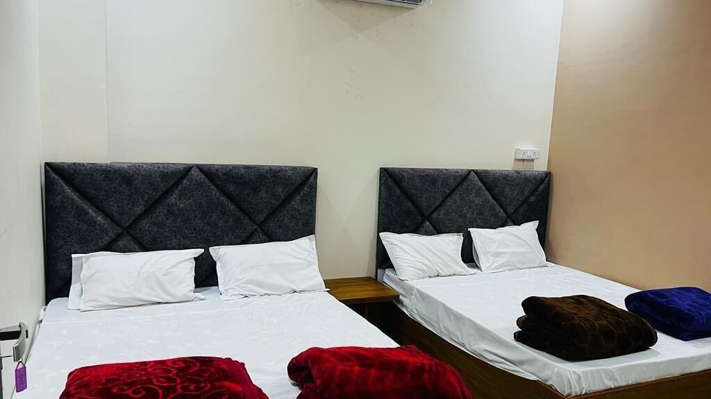 Ein Hotelzimmer mit zwei Einzelbetten, jeweils mit dunklem Kopfteil und weißer Bettwäsche.