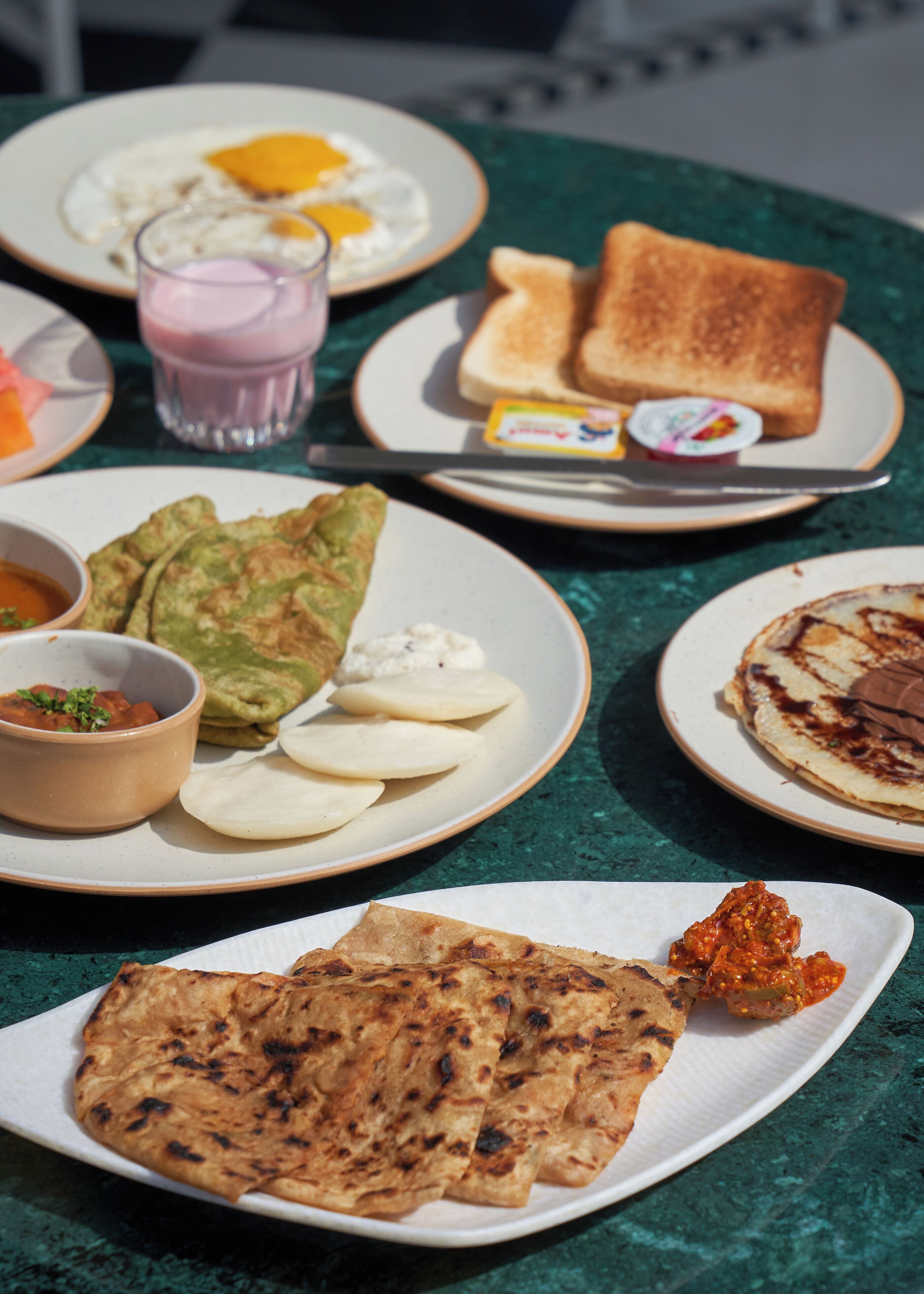 A table with various breakfast items including toast, eggs, and flatbreads.