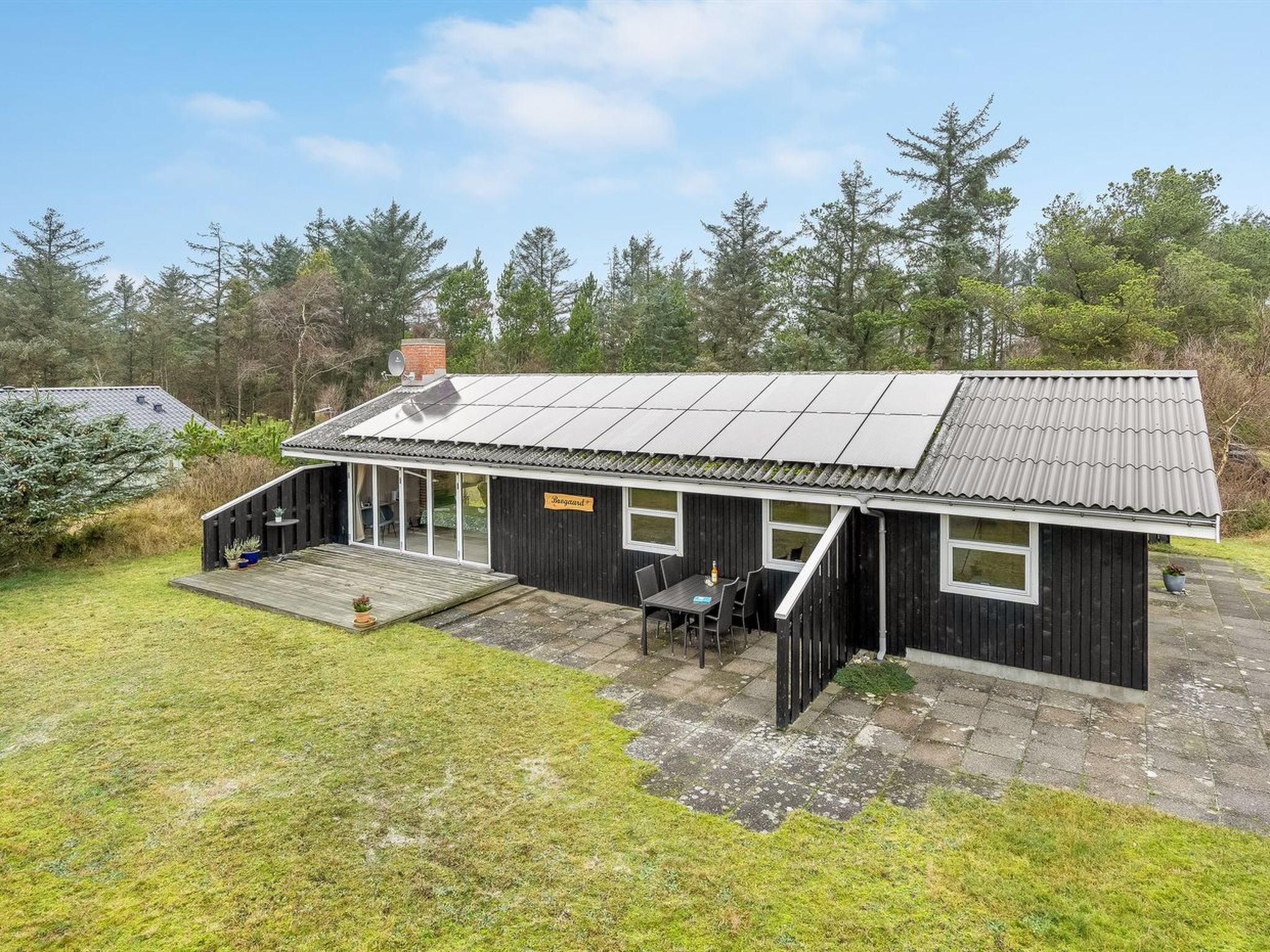 Un petit bâtiment d’un seul étage, doté d’un toit en pente, d’un patio couvert et d’une enseigne indiquant qu’il s’agit d’un sauna.