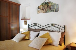 Ein Schlafzimmer mit Bett, Holzschrank und einem Wandbild.