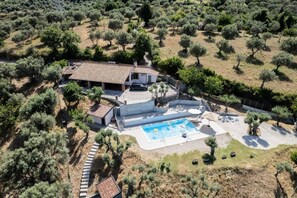 An aerial view of a house with a swimming pool, surrounded by olive trees and a stone pathway. - VVilla Cosentino is an enchanting retreat immersed in the Mediterranean nature of Sicily, where peace, privacy and authenticity come together. Surrounded by centuries-old olive trees, fruit trees and breathtaking sea views, this villa is the ideal place  (Acquedolci)