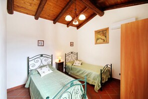 A bedroom with two beds, wooden ceiling beams, a chandelier, and a framed picture on the wall. - VVilla Cosentino is an enchanting retreat immersed in the Mediterranean nature of Sicily, where peace, privacy and authenticity come together. Surrounded by centuries-old olive trees, fruit trees and breathtaking sea views, this villa is the ideal place  (Acquedolci)