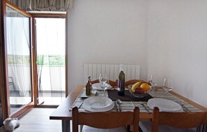 A dining table set with plates, glasses, cutlery, and a fruit bowl. - Peaceful Flat Surrounded by Nature (Umag)
