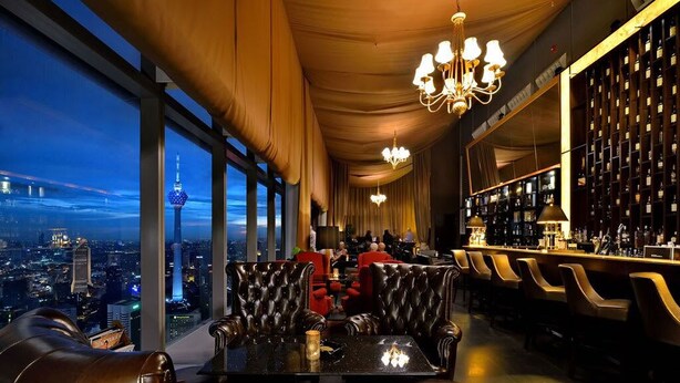 A high-rise bar with leather seating, a city view, and a wine rack. - Cozy High-Floor Suasana KL with City Views (Kuala Lumpur)