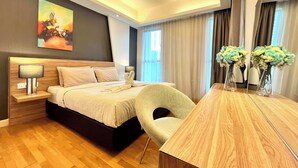 A modern hotel room with a wooden bed, a desk, a chair, and a large mirror. - Cozy High-Floor Suasana KL with City Views (Kuala Lumpur)