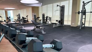 A gym with various exercise equipment, including dumbbells, benches, and weight machines. - Setia Tri-Suite(8) by Homey Planet (Bayan Lepas)