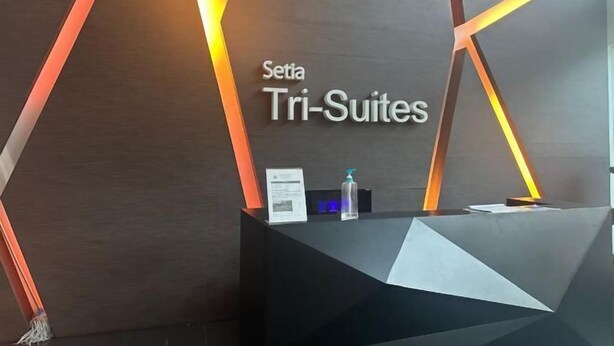 A reception desk with the text "Setia Tri-Suites" and a modern geometric design. - Setia Tri-Suite(8) by Homey Planet (Bayan Lepas)