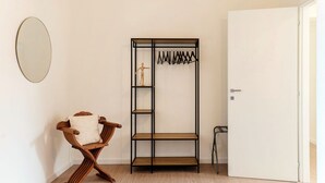 A room with a wooden bench, a black metal wardrobe, and a white door. - Casa Sara - MyHomeinComo (Como)