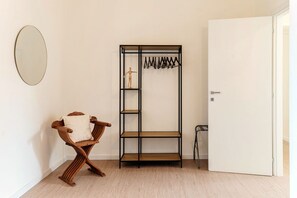 A room with a wooden bench, a black metal wardrobe, and a white door. - Casa Sara - MyHomeinComo (Como)