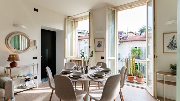 A dining area with a round table, chairs, and potted plants. - Casa Sara - MyHomeinComo (Como)