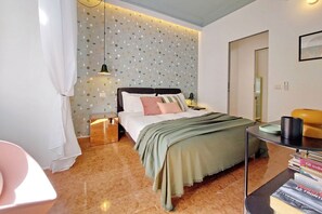 A modern bedroom with a bed, bedside tables, a nightstand, a chair, and a bookshelf. - Lussuoso appartamento vicino al Colosseo (Roma)