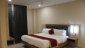 Een slaapkamer met een groot bed, een houten hoofdbord, nachtkastjes en een plafondventilator.