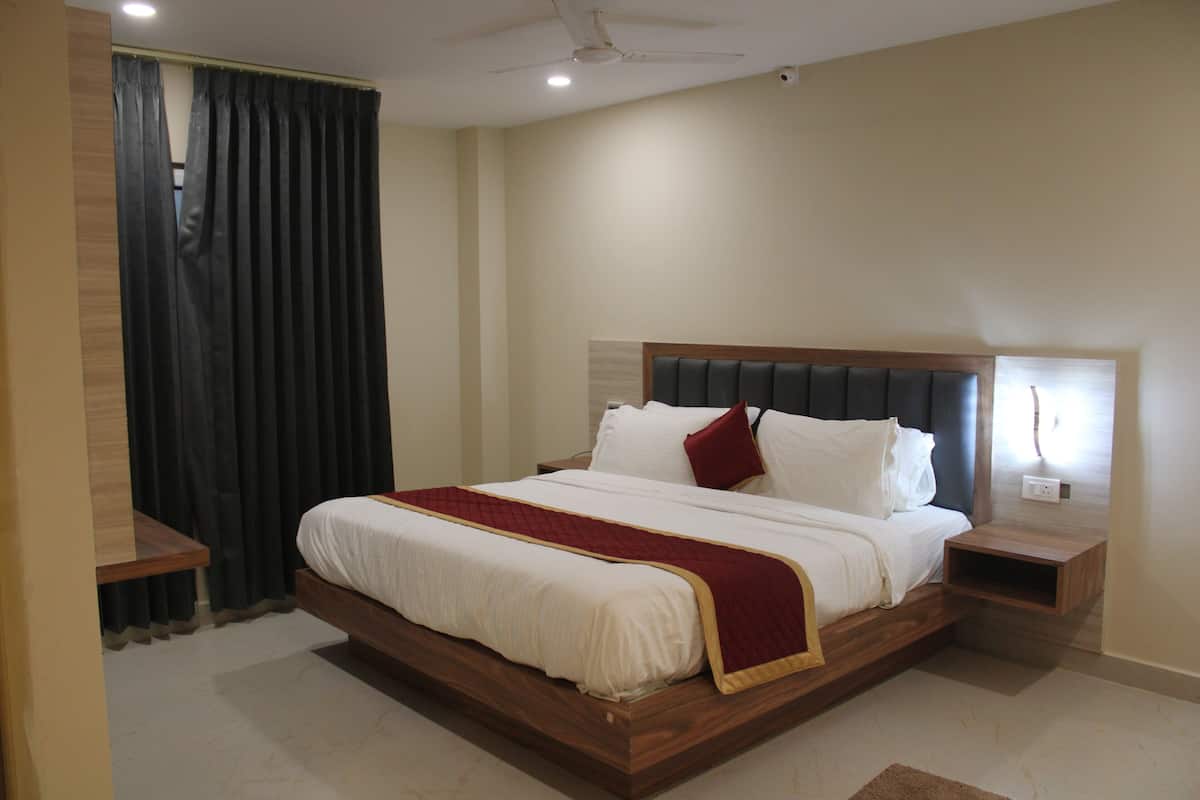 Een slaapkamer met een groot bed, een houten hoofdbord, nachtkastjes en een plafondventilator.