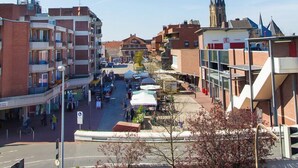 A street view with buildings, a church spire, and a clear blue sky. - Refugium 1 (Emsdetten)