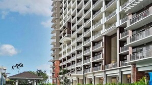 A multi-story hotel with balconies, a swimming pool, and a covered area with plants. - Cozy LUZZO HOME 1-br luxury condo in  Kapitolyo pasig area 2mins away from BGC (Pasig)