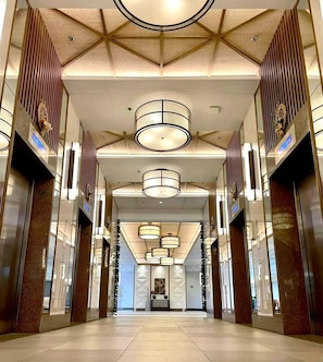 A spacious, modern lobby with a geometric ceiling design, multiple chandeliers, and a central decorative piece. - Cozy LUZZO HOME 1-br luxury condo in  Kapitolyo pasig area 2mins away from BGC (Pasig)